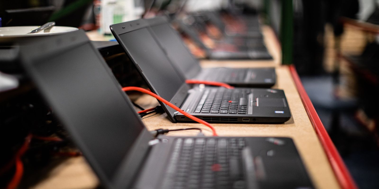 rental laptops in a row being imaged on a warehouse bench