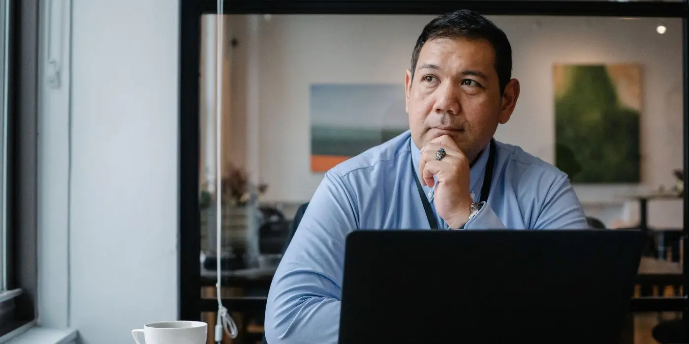 Event leader reflecting at laptop in office