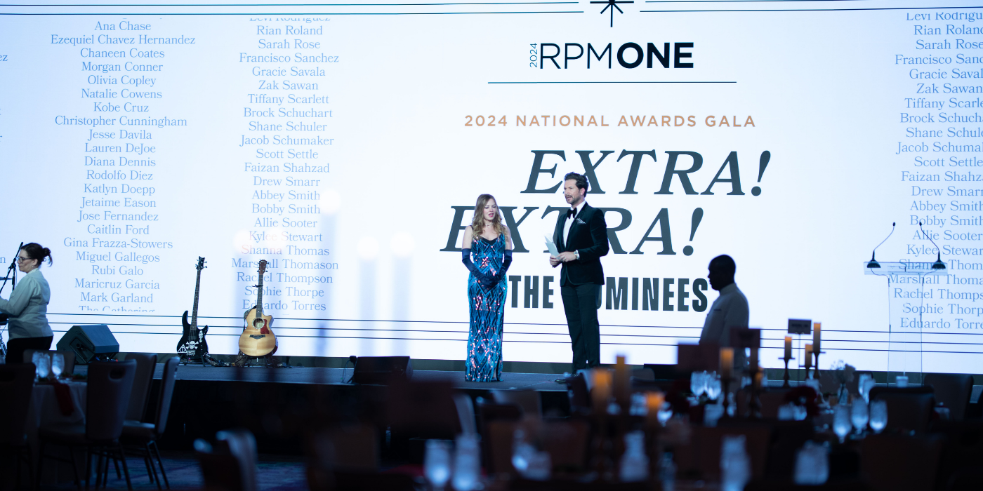Hosts presenting at a corporate awards gala with branded backdrop