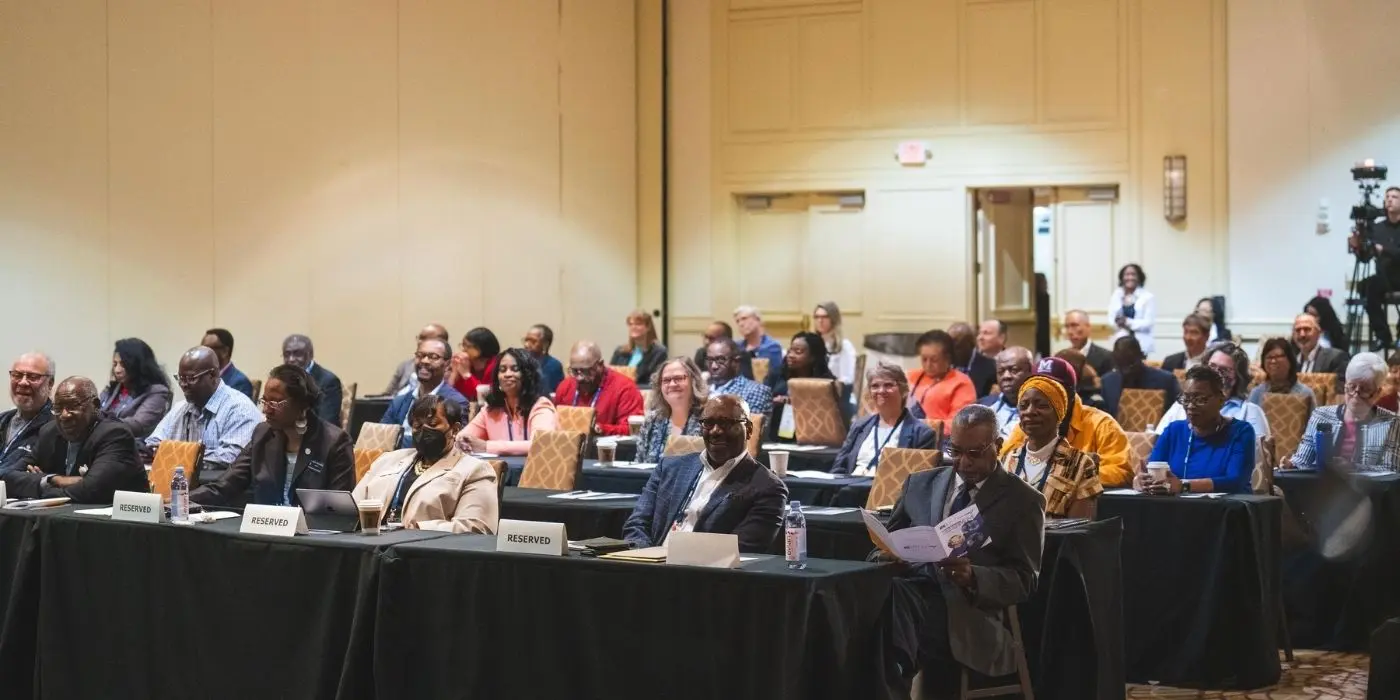 Attendees seated at tables at a corporate executive event