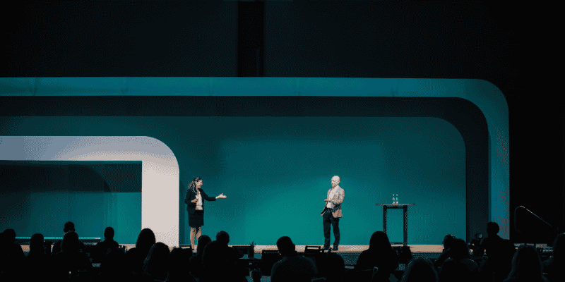 Two speakers on minimalist teal stage