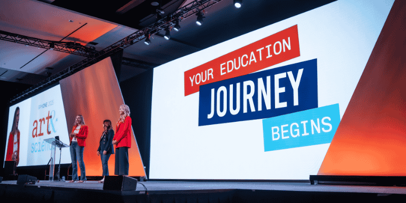 Presenters on stage with bold branded LED graphics