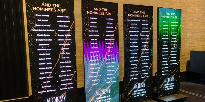 Four LED poster displays showing award nominees at corporate event