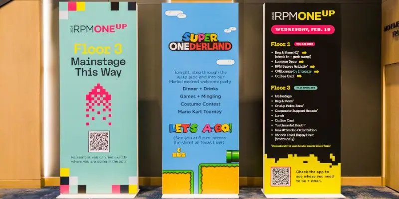 Three branded print banner stands with event wayfinding information