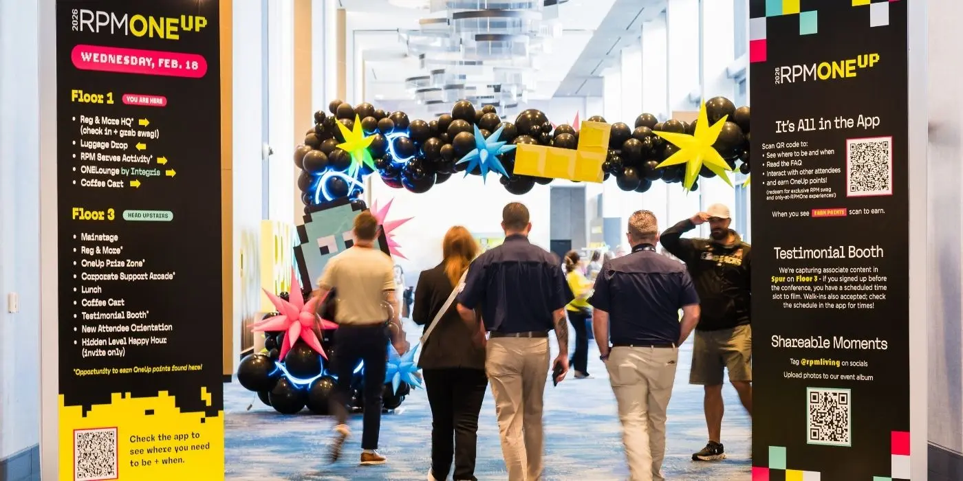 Branded event signage flanking a decorated conference hallway entrance