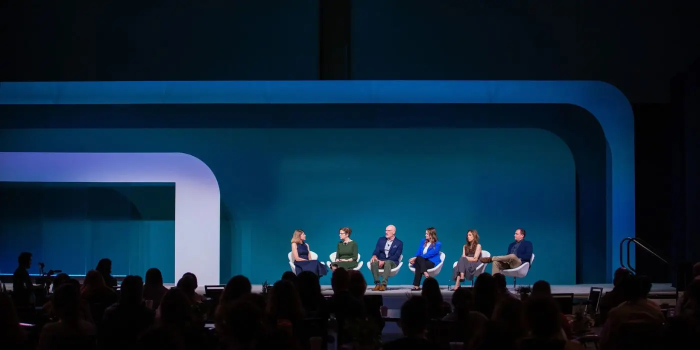 Panel on blue stage with curved scenic frames