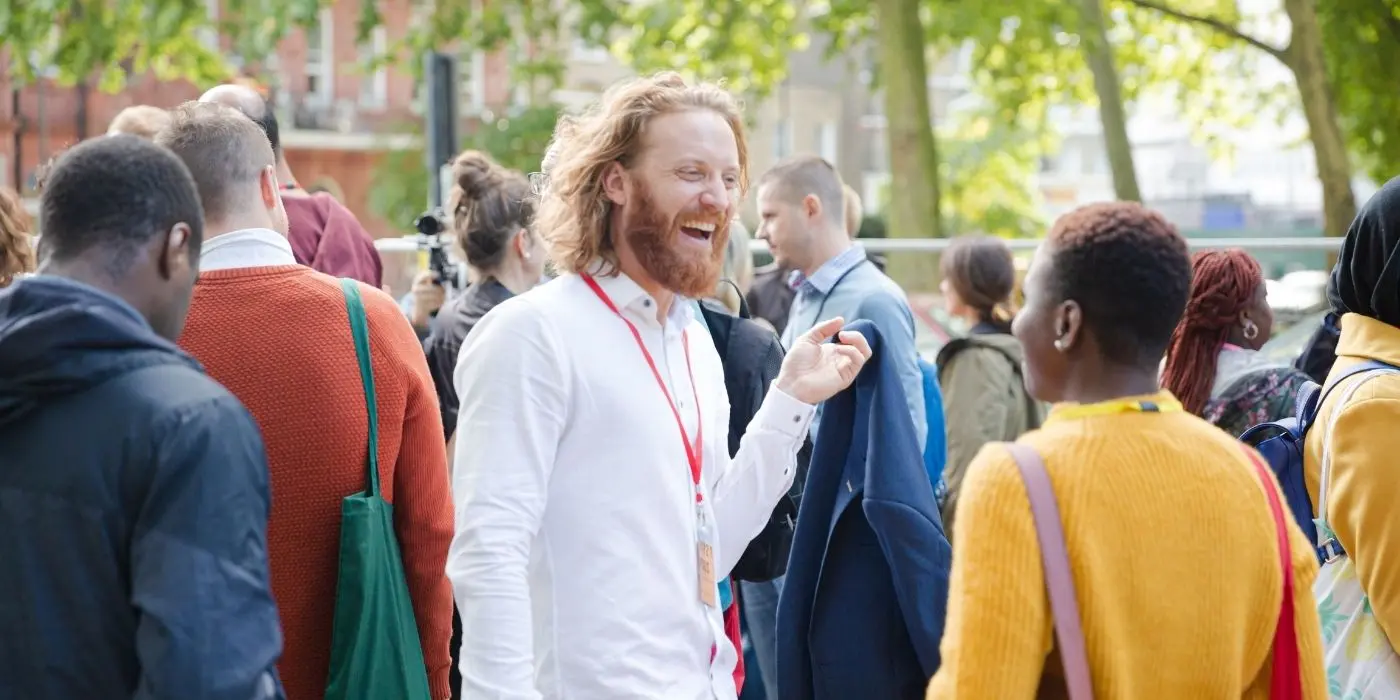 Conference attendee networking and laughing outdoors